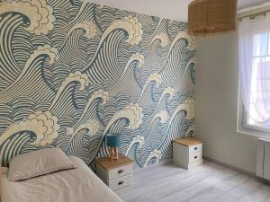 a bedroom with a blue and white wave wallpaper at Pirou plage La Villa Mosca in Pirou