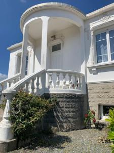 a white house with a porch and a white door at Pirou plage La Villa Mosca in Pirou