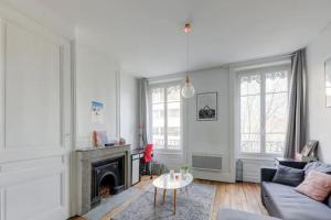 uma sala de estar com um sofá e uma lareira em Bel appartement Haussmannien au coeur du 7ème em Lyon