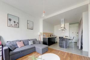 uma sala de estar com um sofá e uma cozinha em Bel appartement Haussmannien au coeur du 7ème em Lyon