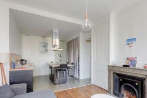 uma sala de estar branca com lareira e uma cozinha em Bel appartement Haussmannien au coeur du 7ème em Lyon