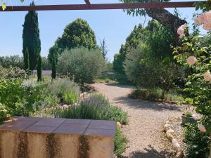 - un jardin avec un banc en pierre au milieu dans l'établissement Gite Amandier, Ferme Bel Air, Riez, à Riez