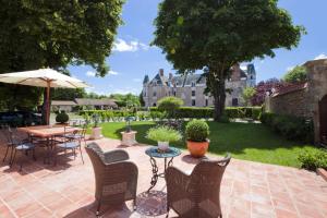 a patio with a table and chairs and an umbrella at Le Gîte du Château de la Vérie in Challans