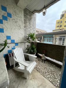 a patio with a white chair and a brick wall at House Lane 123 in Tainan