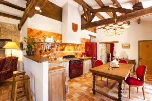 a kitchen with a wooden table and a tableasteryasteryasteryasteryasteryasteryastery at Le Gîte du Château de la Vérie in Challans