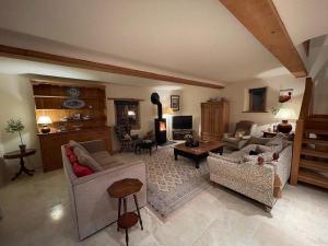 una gran sala de estar con sofás y una mesa. en Yew Tree Cottage, en Shepton Mallet