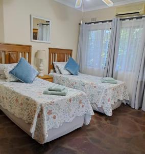 St Lucia的住宿－Stone House，一间卧室设有两张床和两个窗户。
