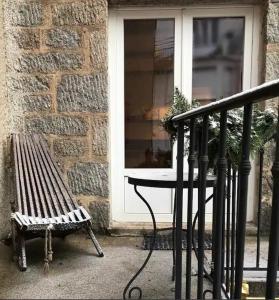 a bench and a table in front of a window at Appartement douillet, plein centre in Le Chambon-sur-Lignon