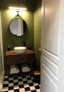 La salle de bains est pourvue d'un lavabo et d'un miroir. dans l'établissement Appartement douillet, plein centre, au Chambon-sur-Lignon