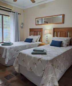 dos camas sentadas una al lado de la otra en un dormitorio en Stone House en St Lucia
