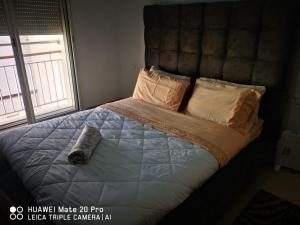 Schlafzimmer mit einem Bett mit Fernbedienung in der Unterkunft Luxus Home in Oujda
