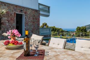 eine Flasche Wein auf einem Tisch mit einem Glas in der Unterkunft Villa Pavlos in Skopelos