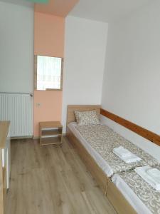a small bedroom with a bed and a table at Family Hotel Kentavar 2 in Byala