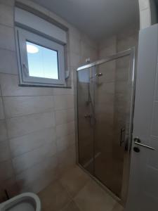 y baño con ducha, ventana y aseo. en Apartments Relax, en Rogoznica