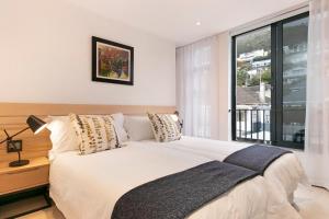 a bedroom with a bed and a large window at The Murex in Cape Town