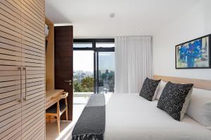 a bedroom with a bed and a desk and a window at The Murex in Cape Town