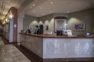 a man sitting at a bar in a hotel lobby at Lucania Palazzo Hotel in Comodoro Rivadavia