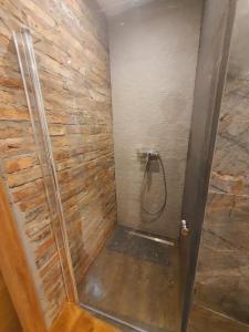 ein Bad mit einer Dusche und einer Steinmauer in der Unterkunft A cozy room near warsaw in Michaelsthal