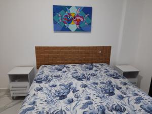 - une chambre avec un lit orné d'une peinture murale dans l'établissement Capitânia Varam, à Guarujá