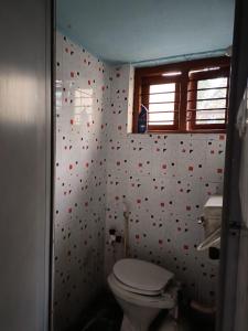 uma casa de banho com WC e uma parede com corações vermelhos em Jeevith em Hunsūr