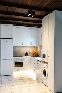 a kitchen with white cabinets and a washer and dryer at Trikorfo Bungalows in Gerakini