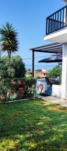 una casa con un patio con una mesa y un árbol en Trikorfo Bungalows, en Gerakini