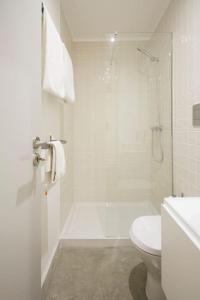 uma casa de banho branca com um chuveiro e um WC. em OHH - Santo Ildefonso flat no Porto