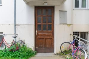 dos bicicletas estacionadas frente a una puerta de madera en Studio Apartment Dominika, en Liubliana