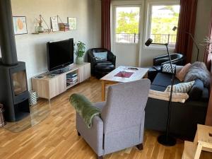 a living room with a couch and a tv and a chair at 8 person holiday home in Hellesøy-By Traum in Bøvågen