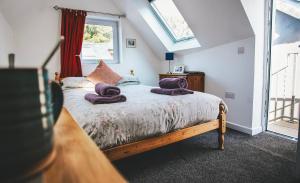 Un dormitorio con una cama con toallas moradas. en The Keep en Tenby