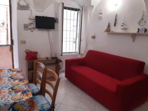 a living room with a red couch and a table at La Maison de Lusè à Sanremo in Sanremo