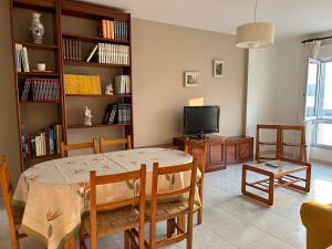 ein Wohnzimmer mit einem Tisch und einem TV in der Unterkunft VUT Pedra de Mula in Portosín