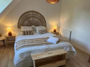 - une chambre avec un grand lit et une tête de lit en bois dans l'établissement Gîte La Bourrelière - Spa Salle de jeux Barbecue Beauval, à Châtillon-sur-Cher