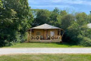 een prieel met een tent in het gras bij Glamping Safarilodge 'Grutte Fiif' met airco, extra keuken op veranda en privé achtertuin in Grou