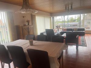een woonkamer met een tafel en stoelen en een bank bij Vakantiehuis Bloemmolenkaai in Diksmuide