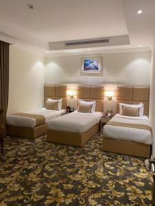 ein Hotelzimmer mit 2 Betten in einem Zimmer in der Unterkunft فندق بلفيو بارك رويال Bellevue Park Royal Hotel in Ta'if