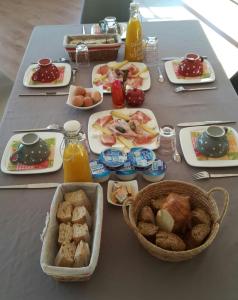 einen Tisch mit Frühstückszutaten und Getränken darauf in der Unterkunft Le Domaine de la Feuilleraie in Coaraze