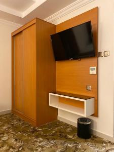 einen Flachbild-TV an der Wand in einem Hotelzimmer in der Unterkunft فندق بلفيو بارك رويال Bellevue Park Royal Hotel in Ta'if