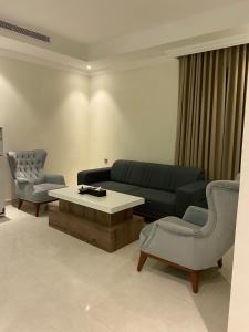 un soggiorno con divano, tavolo e sedie di فندق بلفيو بارك رويال Bellevue Park Royal Hotel a Taif