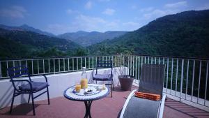 - Balcón con mesa y sillas y vistas a las montañas en Le Domaine de la Feuilleraie, en Coaraze