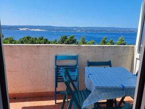 una mesa y sillas en un balcón con vistas al océano en Apartments Filip, en Omiš