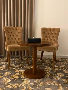 einen Tisch und zwei Stühle in einem Zimmer in der Unterkunft فندق بلفيو بارك رويال Bellevue Park Royal Hotel in Ta'if