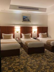 a hotel room with two beds and two lamps at فندق بلفيو بارك رويال Bellevue Park Royal Hotel in Taif