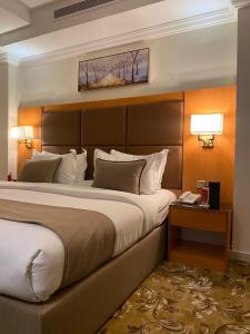 um quarto de hotel com uma cama grande e uma cabeceira em فندق بلفيو بارك رويال Bellevue Park Royal Hotel em Taif