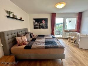 a bedroom with a bed and a table and a window at Schnütgenhof Übernachtung am Biggesee in Attendorn +15 photos
