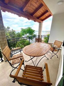 patio con mesa y sillas en el balcón en Apartmani Ferdinanda, en Kustići
