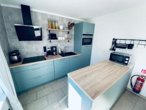 a kitchen with blue cabinets and a counter top at Charlie & Chloé’s beachcondo ***** in De Haan