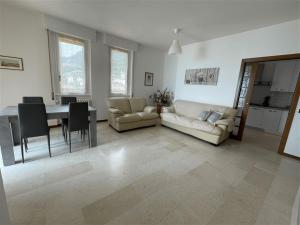 sala de estar con sofá, mesa y sillas en Fabula Home Rental - Casa Pluto en Lovere