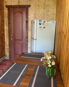 a refrigerator in a room with a door and flowers at Садиба "Донечки" in Tatariv