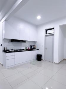 a white kitchen with white cabinets and a door at MVISTA 3BR AirportView CozyStay in Bayan Lepas